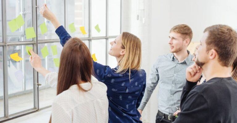 Kuvassa kaksi naista ja kaksi miestä post-it -lappujen parissa työskentelemässä